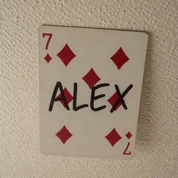 A playing card stuck high on a ceiling.